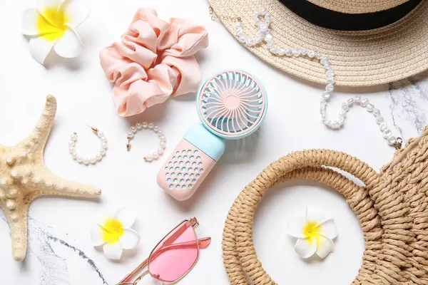 Kadın yaz aksesuarları ve arka planda mini fan.