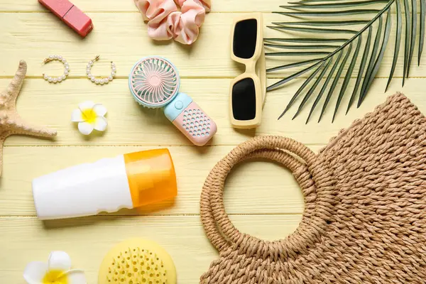 Kadın yaz aksesuarları ve sarı ahşap arka planda mini yelpaze.