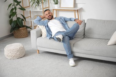 Genç adam izin gününde evde dinleniyor.