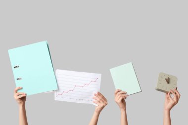 Dosyası, diyagramı, defteri ve saati gri arkaplanda olan kadın elleri. Zaman yönetimi kavramı