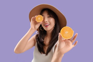 Leylak kaplamalı taze portakallı genç Asyalı kadın.