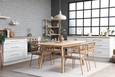 Modern mutfak, yemek masası, tezgah ve raf ünitesi.