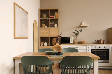 Mutfağın içinde yemek masası, tezgah ve raf ünitesi var.