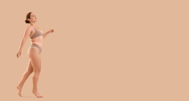 Bej arka planda iç çamaşırlı güzel, kilolu bir kadın ve metin için yeri var.