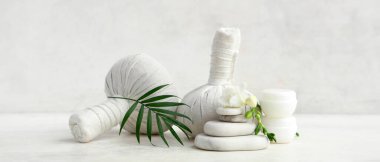 Hafif arkaplanda spa aksesuarları, kozmetik ürünleri, çiçek ve palmiye yaprağı olan kompozisyon