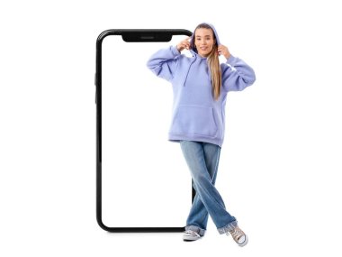 Kapüşonlu şık bir genç kadın ve beyaz arka planda büyük bir akıllı telefon.