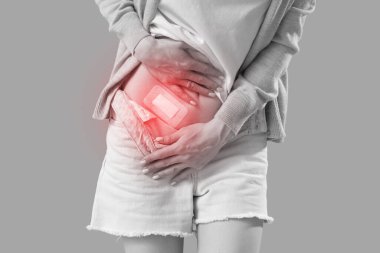 Bej arka planda apandisit ameliyatı sonrası uygulamalı tıbbi yaması olan genç bir kadın. Yakın plan.