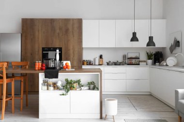 Ahşap masadaki modern aletlerle aydınlık mutfağın içinde.