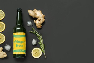 Taze zencefilli bira, biberiye, limon dilimleri ve siyah arkaplanda buz küpleriyle kompozisyon