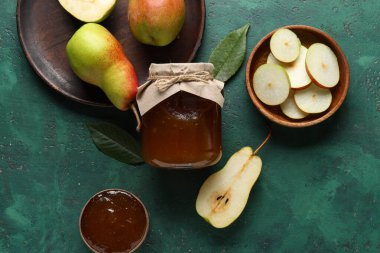 Cam kavanoz armut reçeli ahşap kaseler ve grunge yeşil arka planda tabak