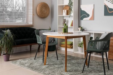 Masası, siyah rahat koltuğu ve raf ünitesi olan güzel bir oturma odası.