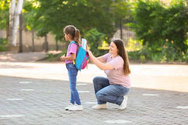 Anne ve kızı okul için sırt çantalarını hazırlıyorlar.