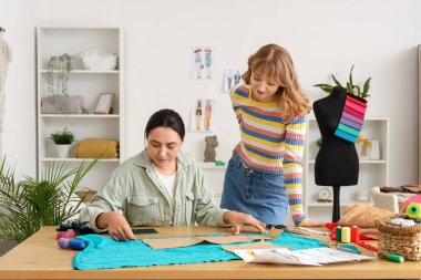 Atölyedeki masada çalışan kadın terziler