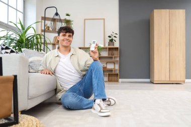 Evdeki klimayı açan yakışıklı genç adam.