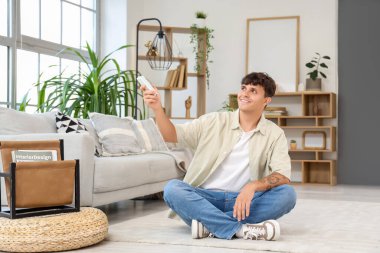 Evdeki klimayı açan yakışıklı genç adam.