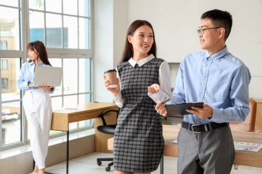 Ofisinde kahve ve pano olan Çinli işadamları.