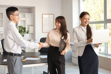 Çinli iş arkadaşları ofiste el sıkışıyor.