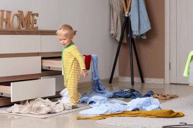 Dağınık elbiseli yaramaz çocuk dağınık odada