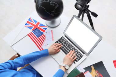 Beyaz masada dizüstü bilgisayar kullanan kadın seyahat blogcusu, üst görünüm