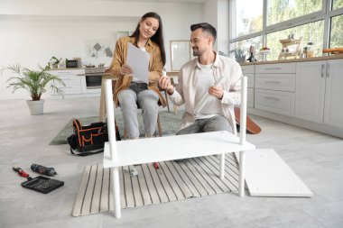 Mutfakta rafları elle monte eden mutlu çift.