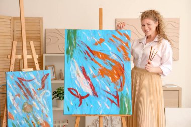 Atölyede fırçaları olan güzel bir sanatçı.