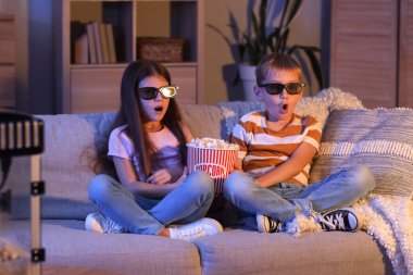 Üç boyutlu gözlüklü ve patlamış mısırlı küçük çocuklar akşam evde çizgi film izlerken şok oldular.