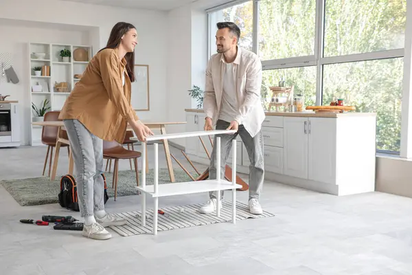 Mutlu çift mutfak raflarını birleştiriyor.