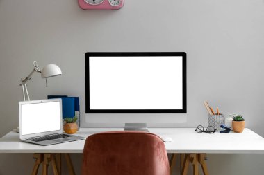 Oturma odasında dizüstü bilgisayarı olan boş bir bilgisayar monitörü.