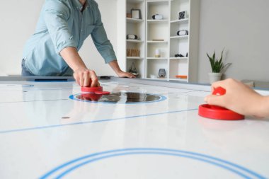 Kız arkadaşıyla evde hokey oynayan genç bir adam, yakın plan.