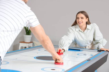 Kocasıyla evde hokey oynayan genç bir kadın.