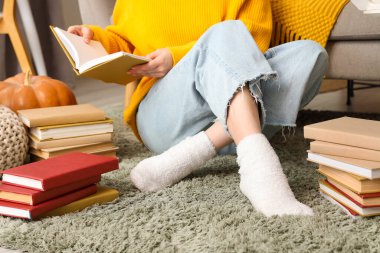 Evdeki halıda kitap okuyan kadın, yakın plan.