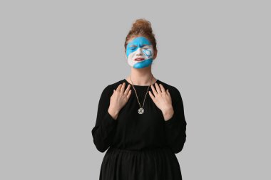 Yüzünde İsrail bayrağı olan dua eden genç bir kadın. Uluslararası Soykırım Anma Günü