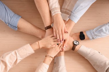 Bir grup insan ellerini masanın üstüne koyuyor.