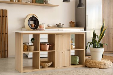 Ada masası, ev bitkileri ve modern buzdolabı olan şık bir mutfak.