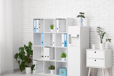 Modern su soğutucusu ve raf ünitesi olan hafif bir ofis.