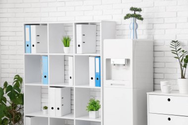 Modern su soğutucusu ve raf ünitesi olan hafif bir ofis.