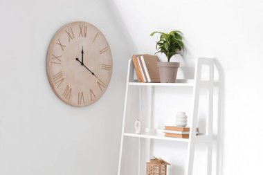 Oturma odasındaki ışık duvarında büyük ahşap bir saat.