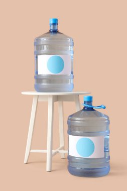 Bej arkaplanda temiz su şişeleri olan masa.