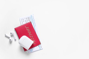 Pasaport, bilet ve arka planda modern kulaklıklar.