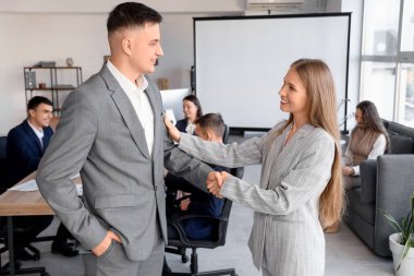 İş ortakları konferans odasında el sıkışıyor.
