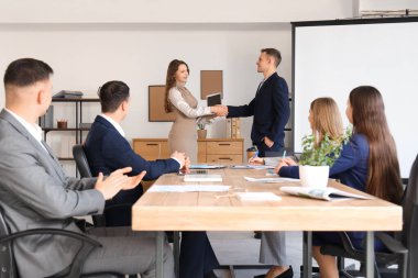 İş ortakları konferans odasında el sıkışıyor.