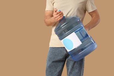 Bej arka planda temiz su şişesi olan bir adam.