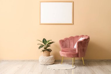 Pembe koltuklu, çiçekli ve boş çerçeveli şık bir oturma odası.