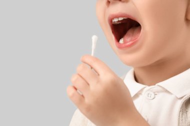 Hafif arka planda pamuk tomurcuğu olan sevimli küçük çocuk, yakın plan.