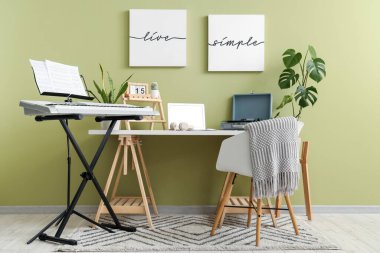 Müzisyen işyeri, kayıt cihazı ve sentezleyicisi olan bir oda.