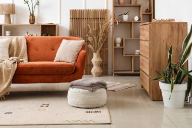 Oturma odasının içinde yastıklı ve ekoseli rahat bir kanepe.