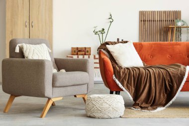 İçinde rahat kahverengi kanepe, masa ve koltuk olan oturma odası.