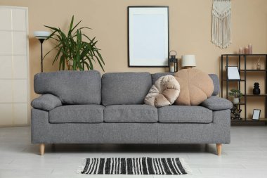 Bej duvarın yanında kanepesi olan bir oturma odası.