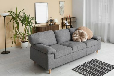 Bej duvarın yanında kanepesi olan bir oturma odası.