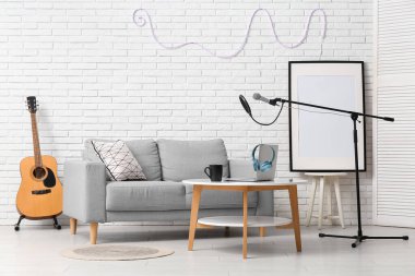 Kanepe, masa ve mikrofonlu kayıt stüdyosunun içi